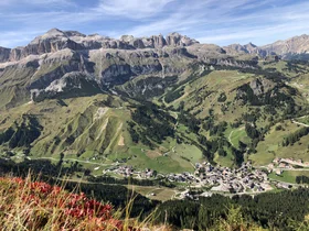 Il tuo Chalet ad Arabba: Chalet Barbara, charme alpino. Veduta panoramica di un villaggio tra montagne e prati verdi nelle Dolomiti
