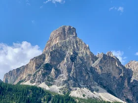 Il tuo Chalet ad Arabba: Chalet Barbara, charme alpino. Montagna rocciosa con foresta verde e cielo azzurro con poche nuvole
