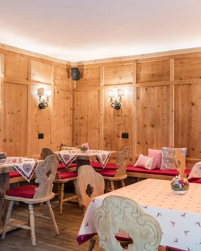 Il tuo Chalet ad Arabba: Chalet Barbara, charme alpino. Sala da pranzo in stile rustico con tavoli, sedie in legno e pareti in legno