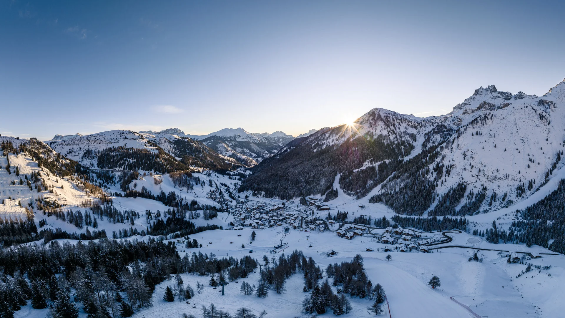 Il tuo Chalet ad Arabba: Chalet Barbara, charme alpino. Paesaggio invernale con villaggio tra montagne innevate al tramonto