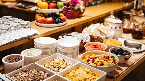 Il tuo Chalet ad Arabba: Chalet Barbara, charme alpino. Buffet di colazione con cereali, frutta fresca e piatti impilati su un tavolo di legno