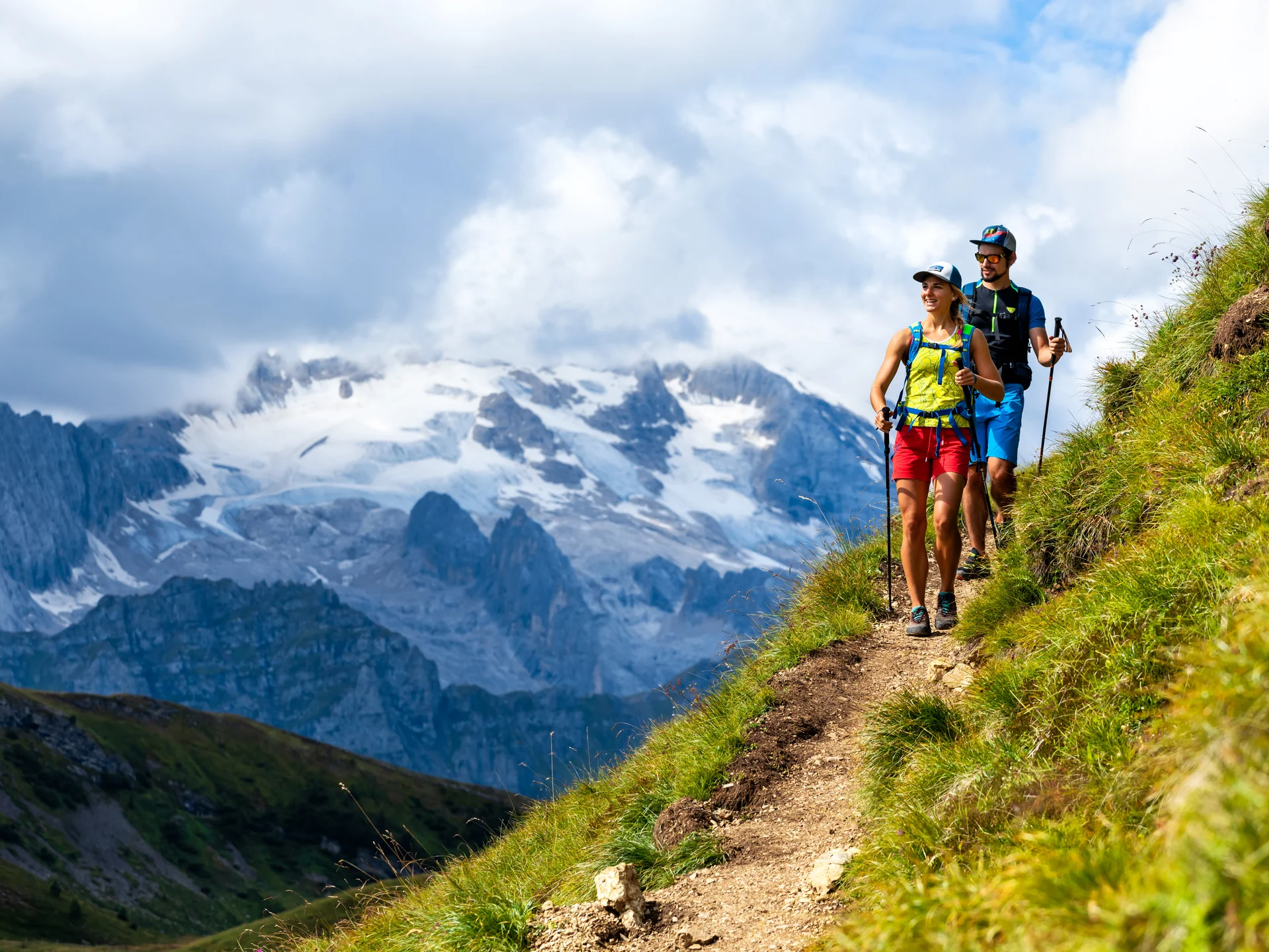 Il tuo Chalet ad Arabba: Chalet Barbara, charme alpino. Due escursionisti su sentiero di montagna con vista su montagne innevate