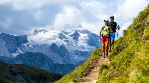 Il tuo Chalet ad Arabba: Chalet Barbara, charme alpino. Due escursionisti su sentiero di montagna con vista su montagne innevate
