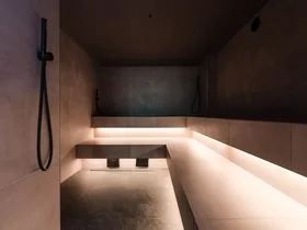 Il tuo Chalet ad Arabba: Chalet Barbara, charme alpino. Interno di sauna moderna con panca illuminata e docce a parete