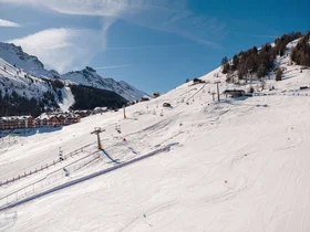 Il tuo Chalet ad Arabba: Chalet Barbara, charme alpino. Pista da sci innevata con impianti di risalita e montagne sullo sfondo