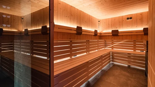 Il tuo Chalet ad Arabba: Chalet Barbara, charme alpino. Interno di una sauna in legno con illuminazione calda e panca ad angolo
